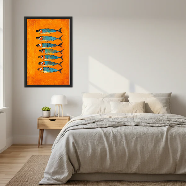 Orange Turquoise Sardines artwork in a black frame above a bed with cream bedding.