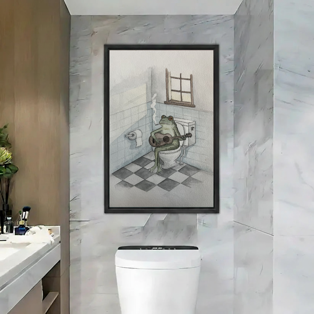 Funny Guitar Bathroom Frog artwork in a black frame above a toilet beside a bathroom basin.