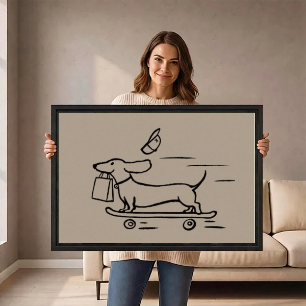 Funny Skateboard Dachshund artwork held in a black frame by a woman beside a cream sofa.