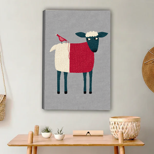Folk Sheep Red Bird artwork as unframed canvas above a wooden console beside woven accents.