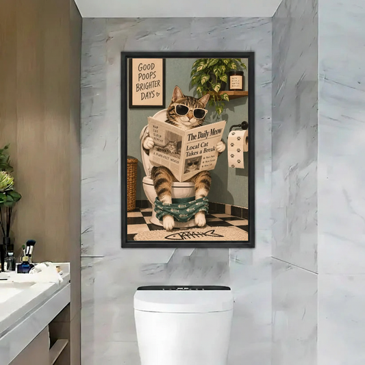 Funny Newspaper Bathroom Cat artwork in a black frame above a toilet beside a bathroom basin.