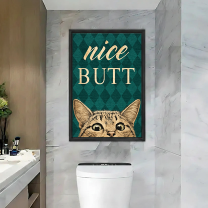 Nice Butt Bathroom Cat artwork in a black frame above a toilet beside a bathroom basin.