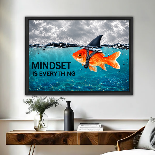 mindset goldfish shark canvas wall art framed above a live-edge desk beside flowers and dark vase.