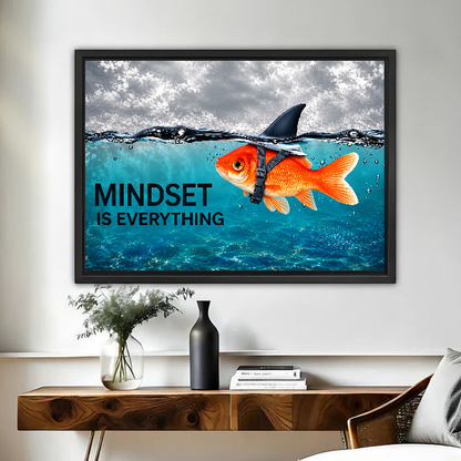mindset goldfish shark canvas wall art framed above a live-edge desk beside flowers and dark vase.