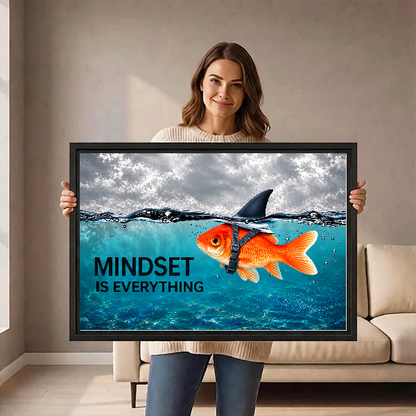 mindset goldfish shark canvas wall art framed as a woman holds the artwork in a taupe room.
