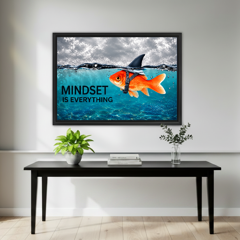 mindset goldfish shark canvas wall art framed above a black console with green plant and vase.