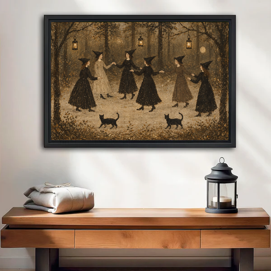 vintage dancing witches canvas wall art framed above a wooden table with lantern and folded blankets.