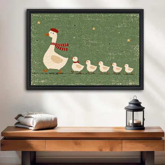 whimsical goose family canvas wall art framed above a wooden table with lantern and folded blankets.