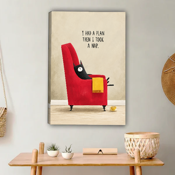 funny napping cat canvas wall art unframed above a light wood console with cacti and basket.
