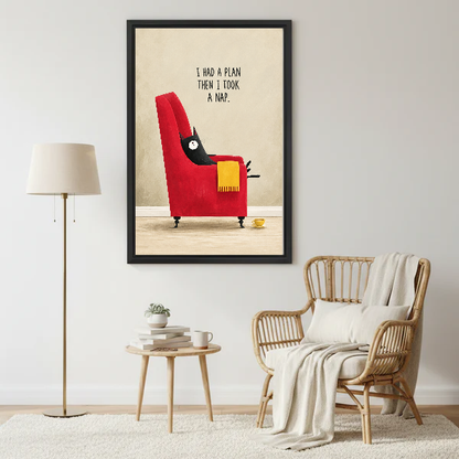 funny napping cat canvas wall art framed beside a wicker armchair with floor lamp and small table.