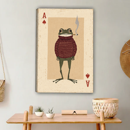 whimsical frog card canvas wall art unframed above a light wood console with cacti and basket.