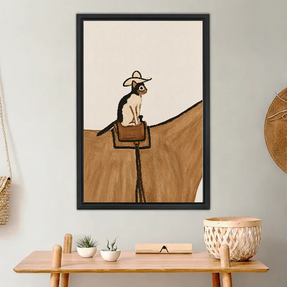 cowboy saddle cat canvas wall art framed above a light wood console with cacti and basket.