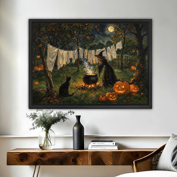 Moonlit Witch Laundry canvas art framed above a wooden desk with a dark vase.