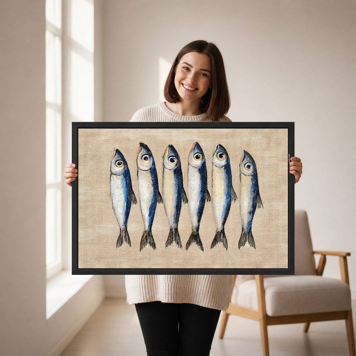 Six Curious Blue Sardines canvas art framed, held by a woman in a neutral room.
