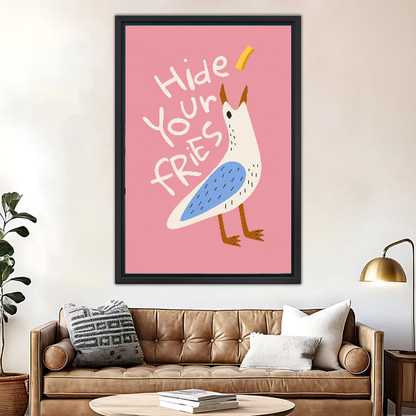 Hide Your Fries Seagull canvas art framed above a brown leather sofa and brass lamp.