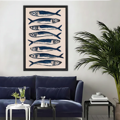 Blue Sardines Canvas Wall Art framed above a navy sofa beside a leafy palm.