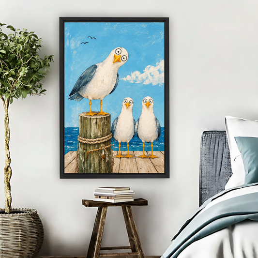 Seagull Trio Canvas Wall Art framed beside blue bedding, a leafy plant, and books.