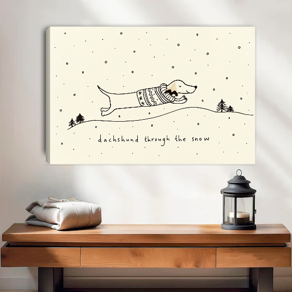 Dachshund Snow Canvas Wall Art unframed above a wood console with linen and a lantern.