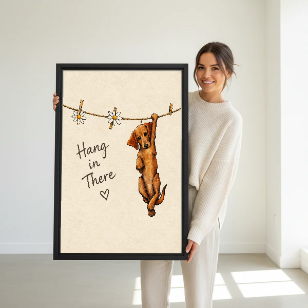 Hang In There Canvas Wall Art held in a black frame by a standing woman in white.