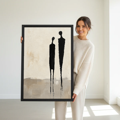 Minimalist Couple Canvas Wall Art held in a black frame by a standing woman in white.