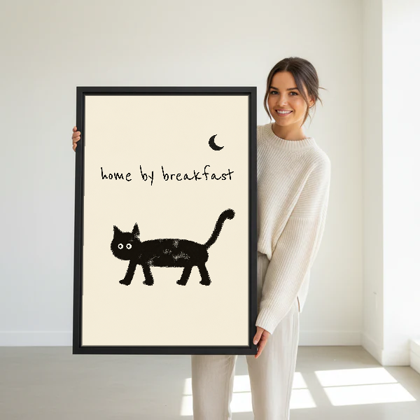 Home By Breakfast Cat Canvas Wall Art held in a black frame by a standing woman in white.