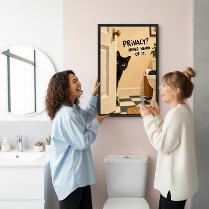 Privacy Cat Bathroom Canvas Wall Art held by two women beside a bathroom mirror and toilet.