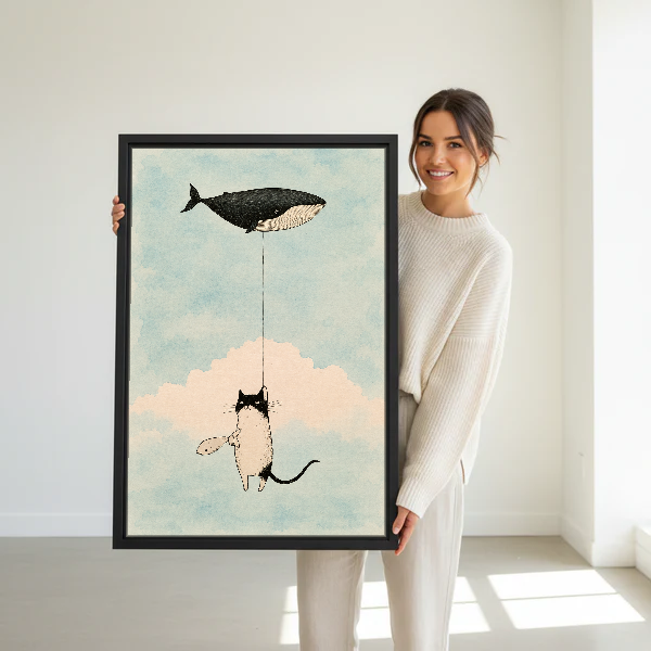 Cat Whale Balloon Dream Canvas Wall Art held in a black frame by a woman in cream.