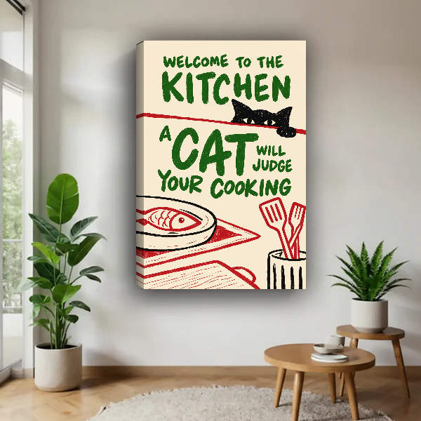Kitchen Cat Food Critic Canvas Wall Art unframed above a pale wood table beside green plants.