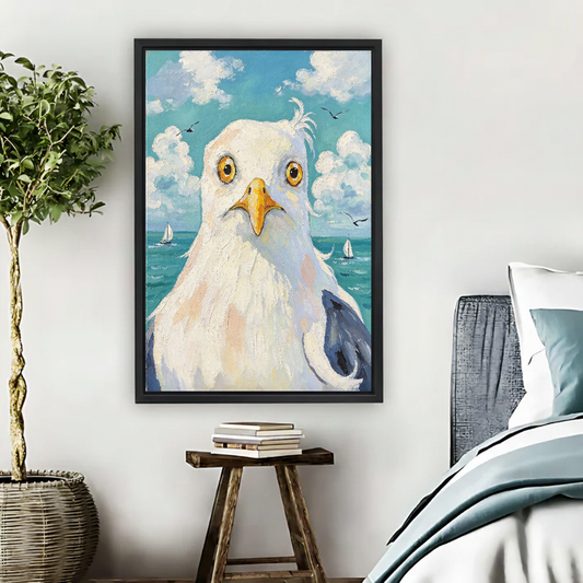 Wide Eyed Seagull Canvas Wall Art framed above pale blue bedding beside books and plants.