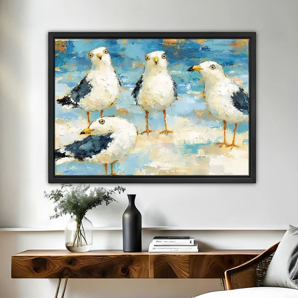 Seaside Gull Gathering Canvas Wall Art framed above a wood console with black vase and branches.