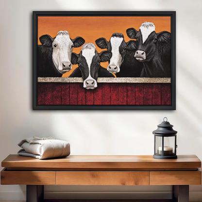 Four Curious Cows Canvas Wall Art framed above a wood console with lantern and folded linen.