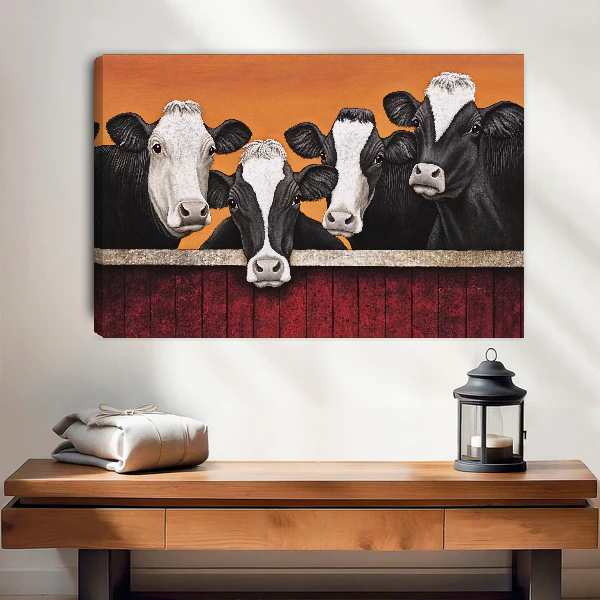 Four Curious Cows Canvas Wall Art unframed above a wood console with lantern and folded linen.