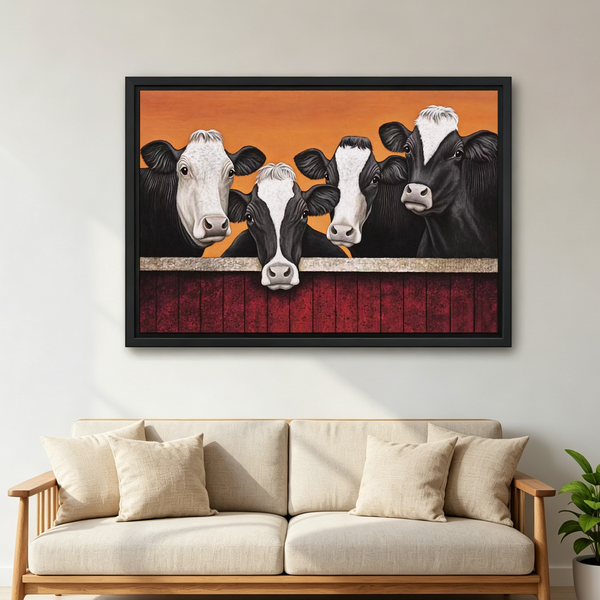 Four Curious Cows Canvas Wall Art framed above a cream sofa with wooden arms.