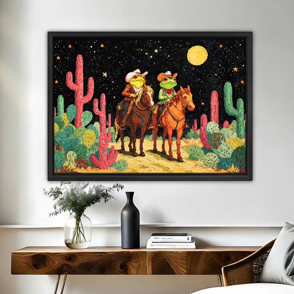 Moonlit Frog Cowboy Riders Canvas Wall Art framed above a figured wooden console with a black vase.