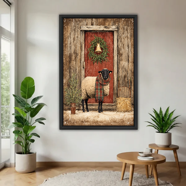 Christmas Barn Scarf Sheep Canvas Wall Art framed above a pale wood table beside green plants.