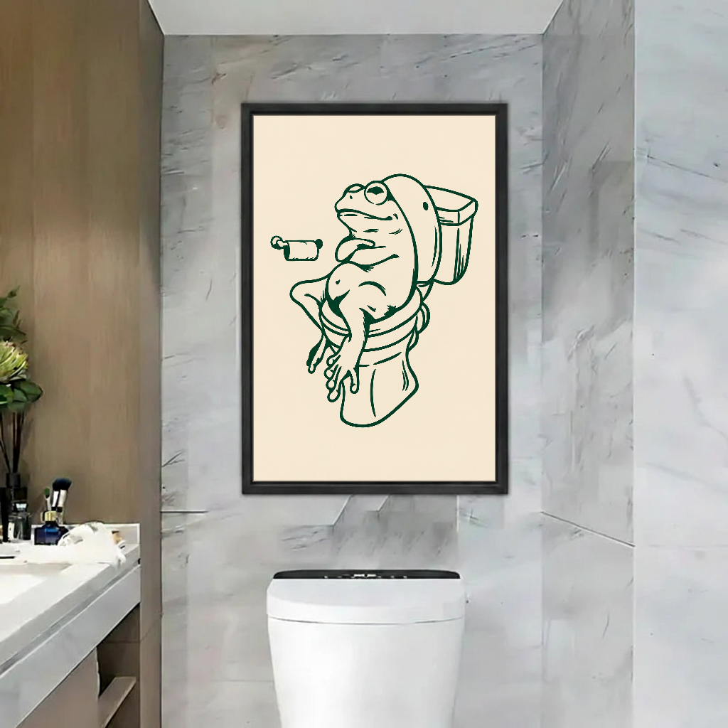 Relaxed Frog Bathroom Break Canvas Wall Art framed above a toilet against gray marble bathroom walls.