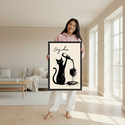Say When Wine Cat Canvas Wall Art held in a black frame by a woman in pink.
