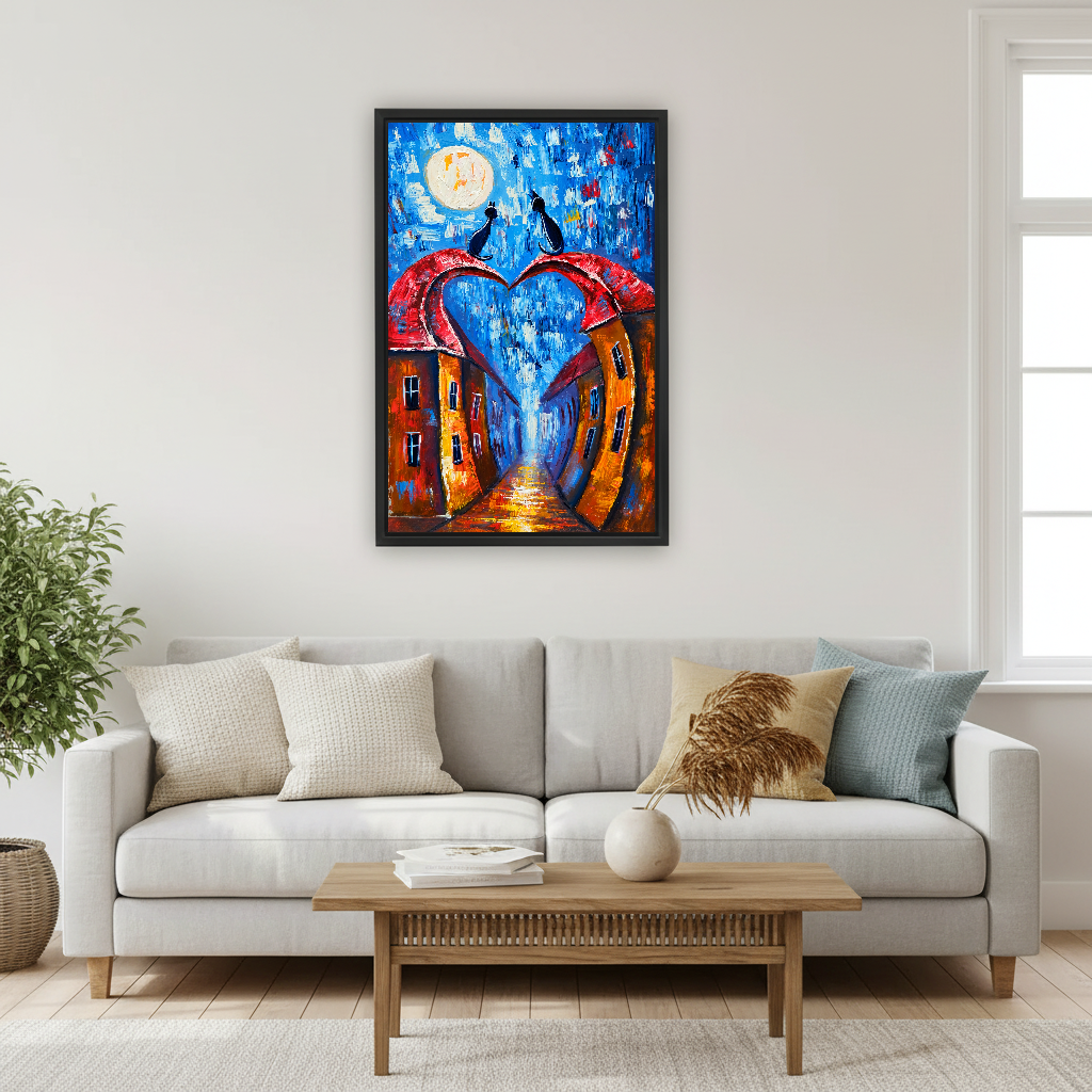 Moonlit Heart Rooftop Cats Canvas Wall Art framed above a cream sofa with blue cushions.