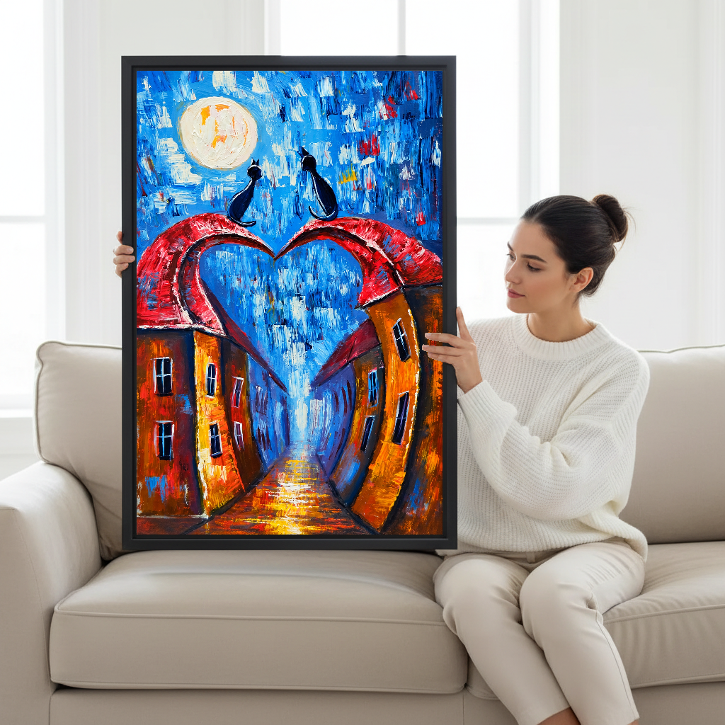 Moonlit Heart Rooftop Cats Canvas Wall Art held by a seated woman beside a cream sofa.