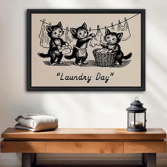 Framed Laundry Day kittens canvas wall art with vintage black linework above a bed with white bedding.