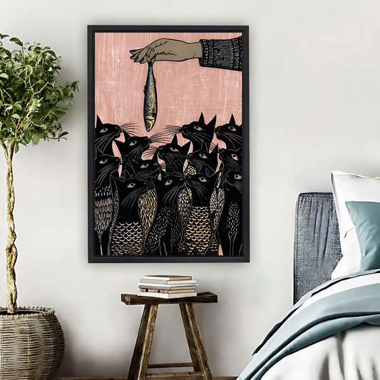  Linocut style framed canvas wall art of black cats reaching for a fish on pink background hung beside a bed in a boho bedroom