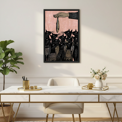 Framed linocut black cats and fish wall art hung above a marble desk with gold accents in a chic home office