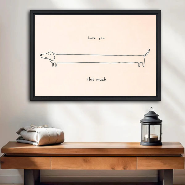 Framed love you this much dachshund canvas wall art with minimalist black linework displayed above a wooden console table.