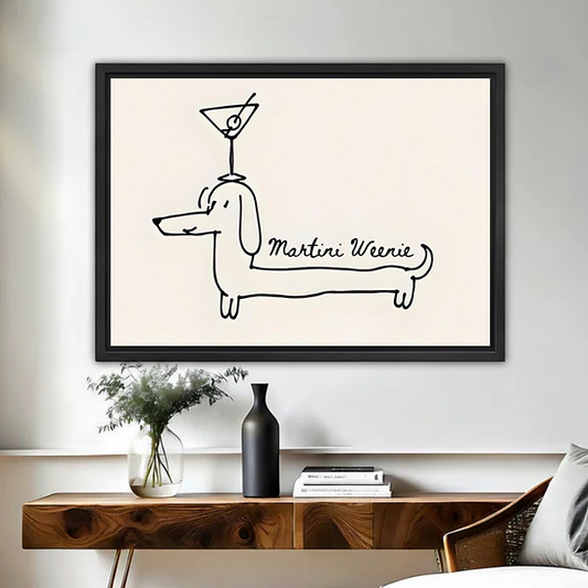 Minimalist Martini Weenie dachshund framed wall art with black line drawing on beige background, hung above a wooden console table with vase and books