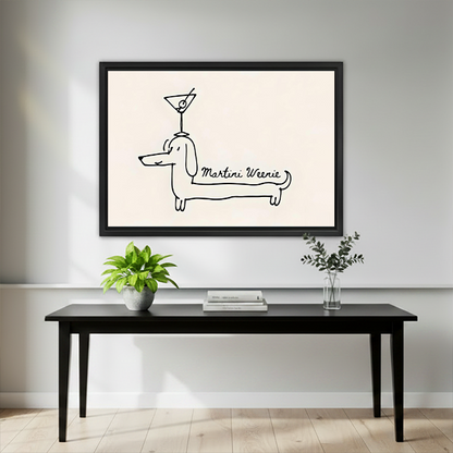 Martini Weenie dachshund minimalist framed wall art mounted above a black console table with green plants and a glass vase in a light gray interior