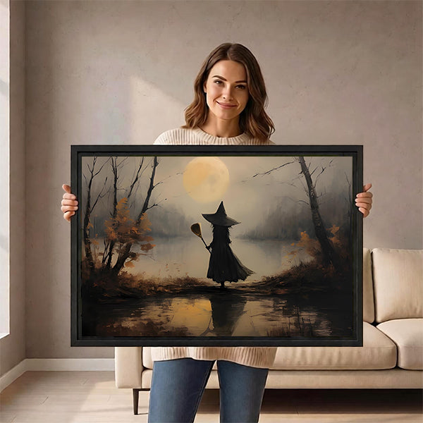 Smiling woman holding framed vintage witch moon canvas wall art in front of a cream sofa