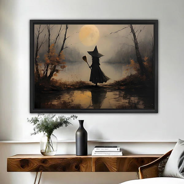 Moody vintage witch moon canvas wall art framed above a walnut console with black vase and books