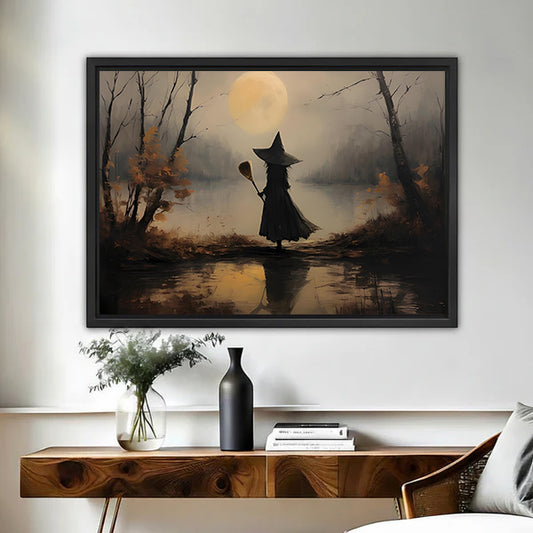 Moody vintage witch moon canvas wall art framed above a walnut console with black vase and books