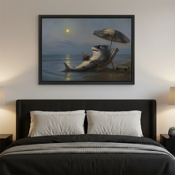 Woman holding black-framed moonlit beach shark canvas wall art showing a shark with a drink beneath a beach umbrella.