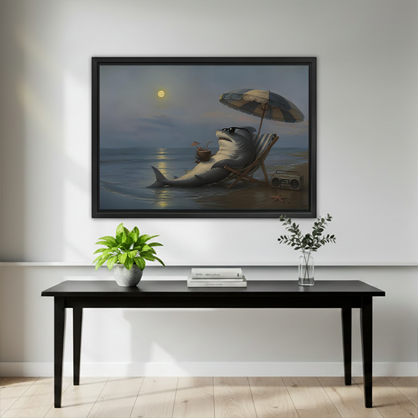 Black-framed moonlit beach shark canvas wall art above a wooden console with flowers, a black vase, and books.